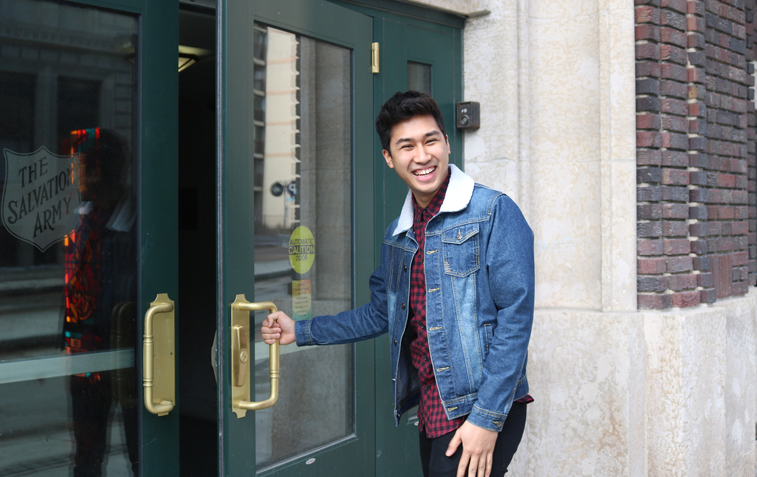 A male student opening the door at the front entrance.