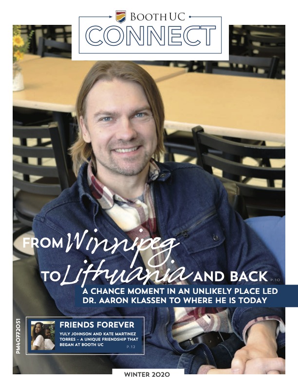 A male professor sitting down smiling with text overlay that says "From Winnipeg to Lithuania and Back"