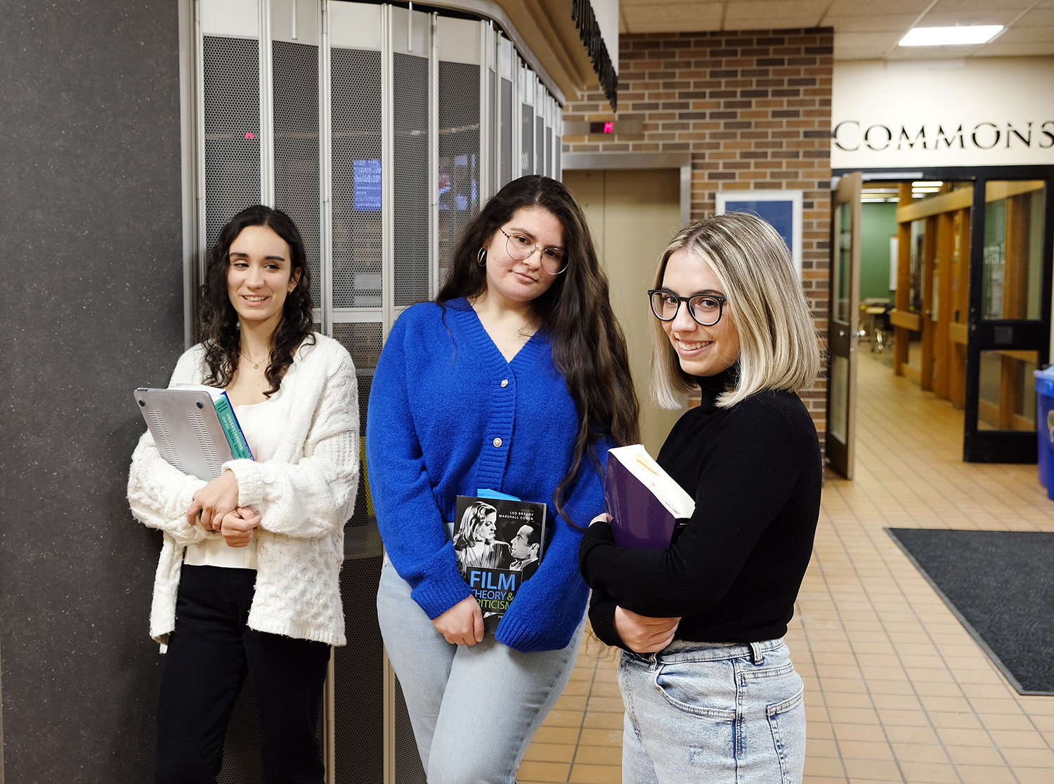 Three female students with textbooks.