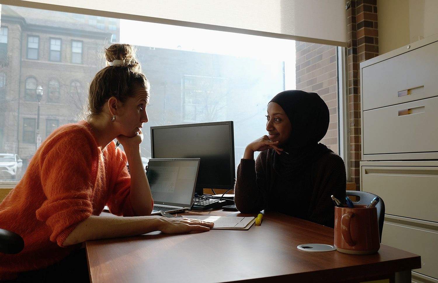 A student sitting across a desk from a learning coordinator.