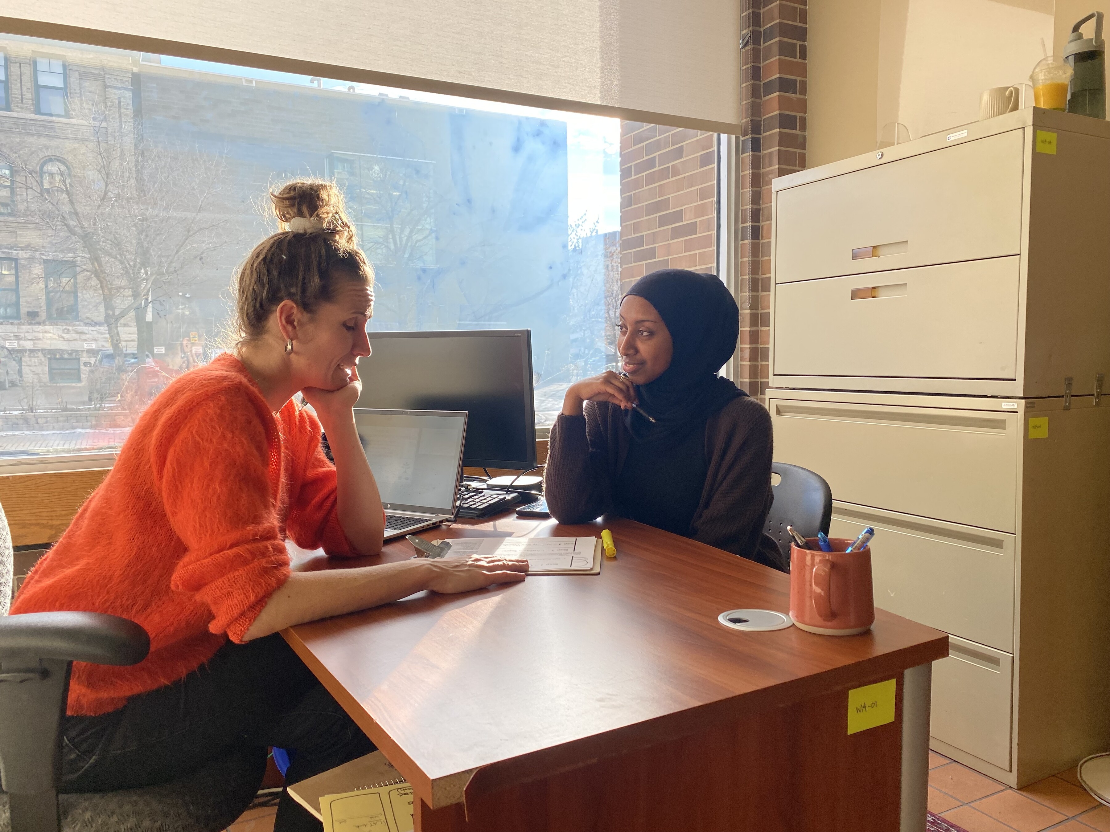 A student sits across the desk from a learning coordinator.