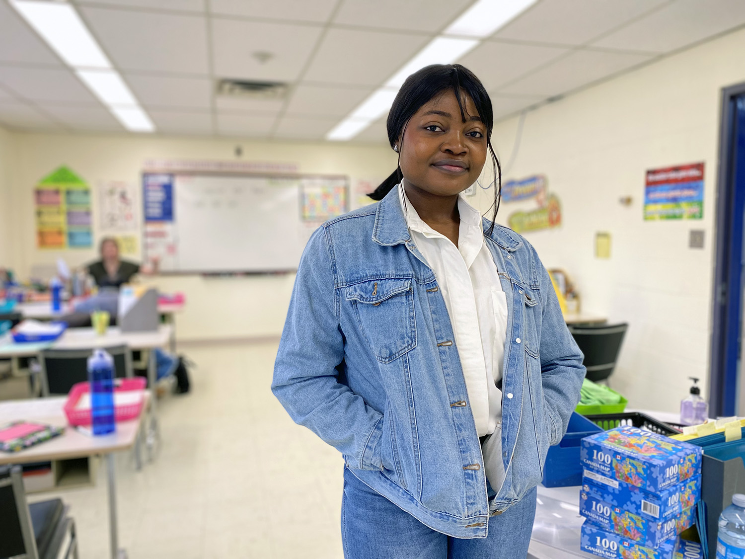 A woman stands in a classroom at a local organization.