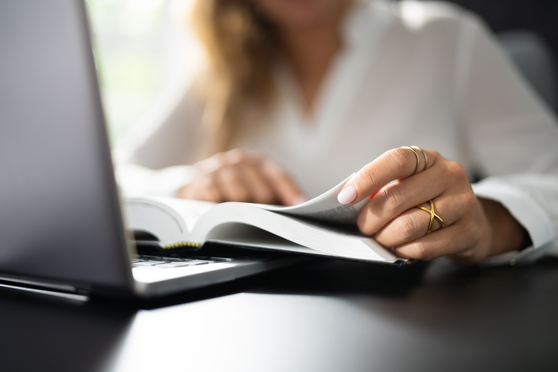 Woman turning the page in a textbook.