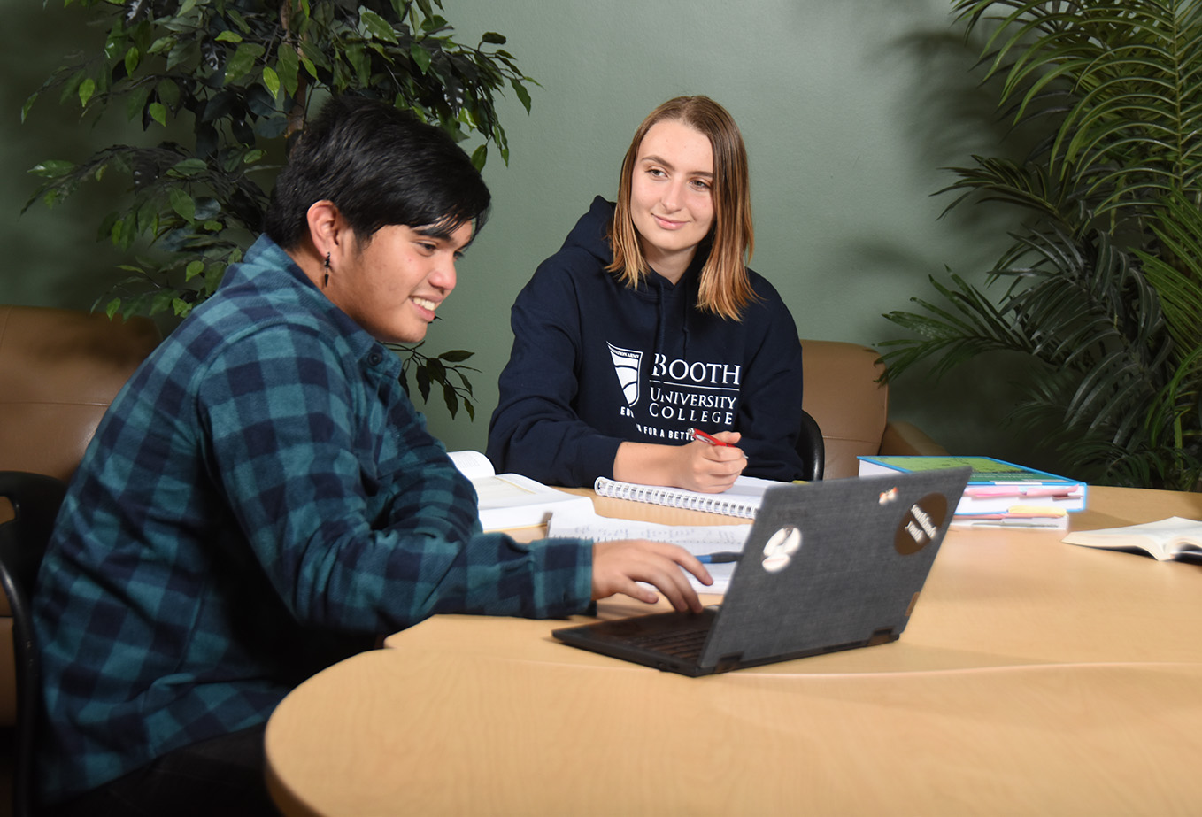 Two students working together at a table.