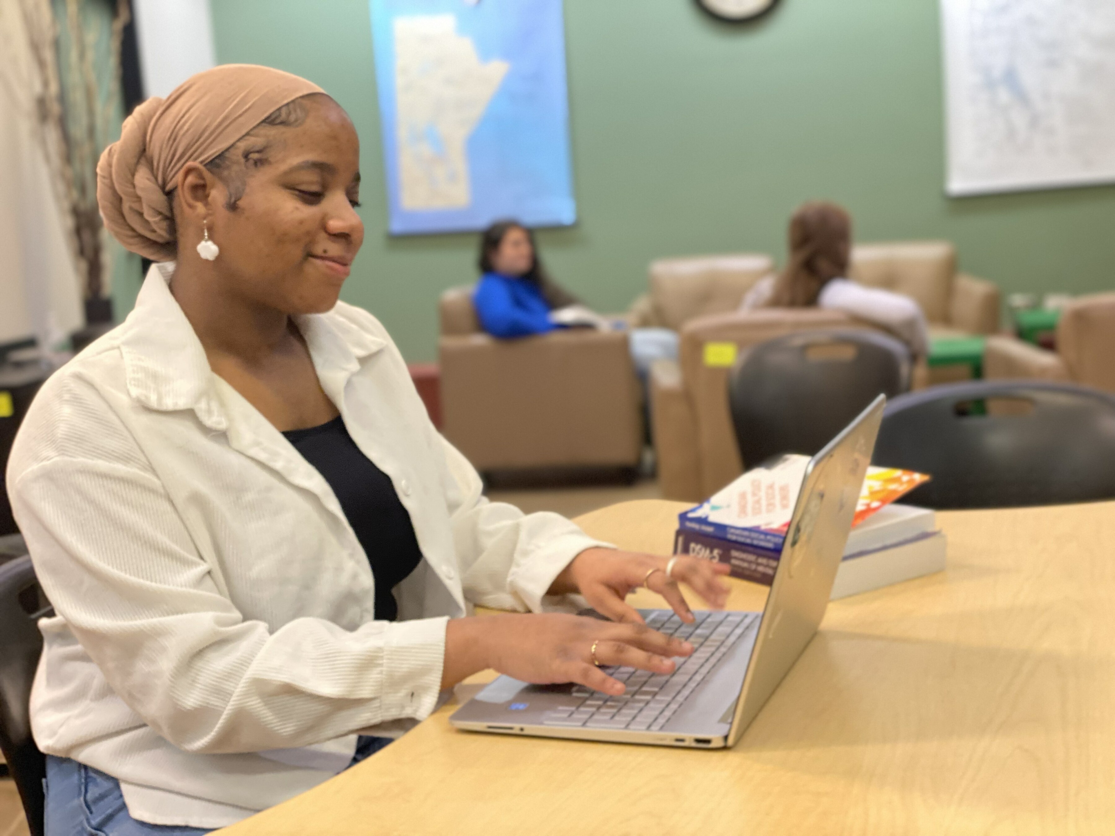 Mayah typing on her computer in the student's lounge.