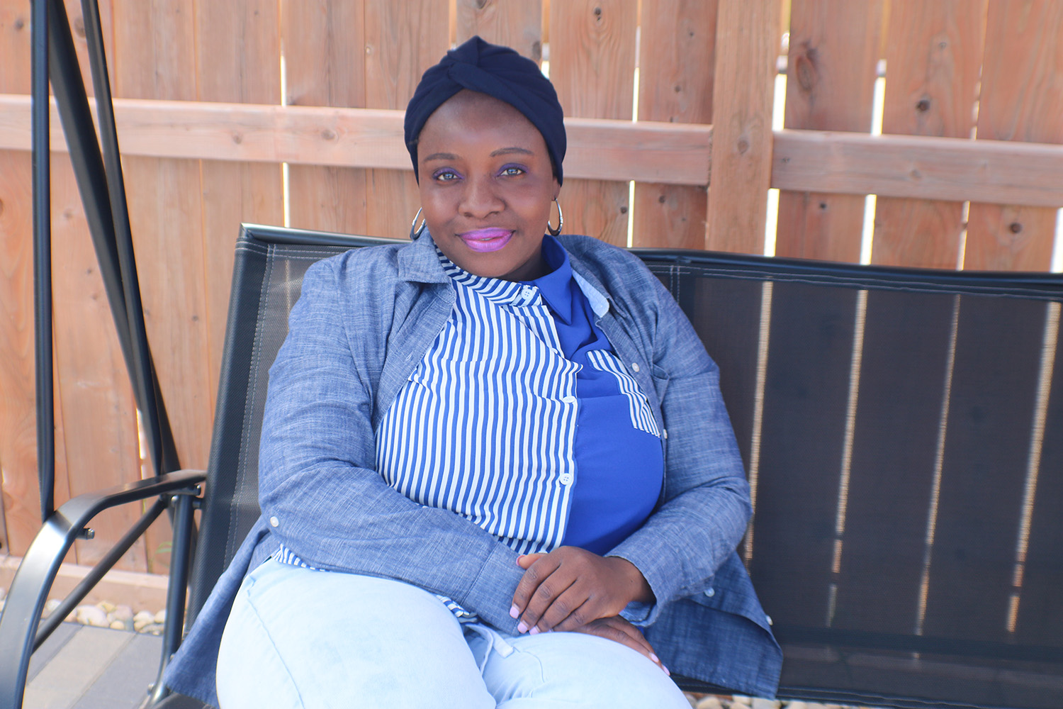 Olaitan sitting on a bench outside.